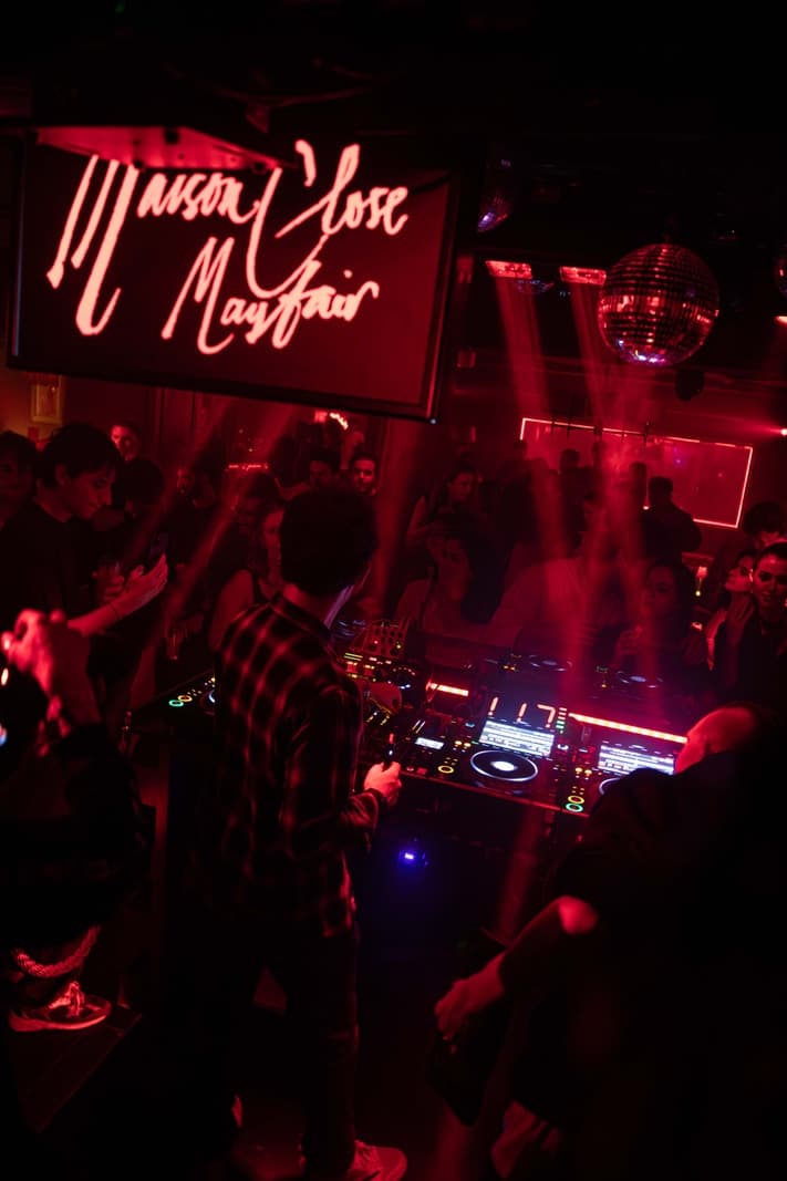 Low-lit Mayfair nightclub interior with table seating and atmospheric lighting