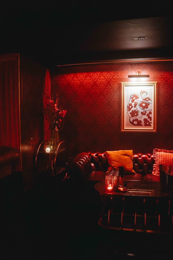 Guests on a London nightclub dancefloor lit by phone screens at night