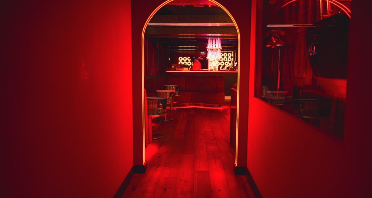 The arched corridor in red light leading into Rumour, Mayfair