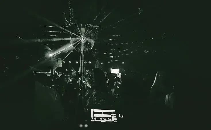 Late-night London after-party scene with neon lights and an energetic crowd