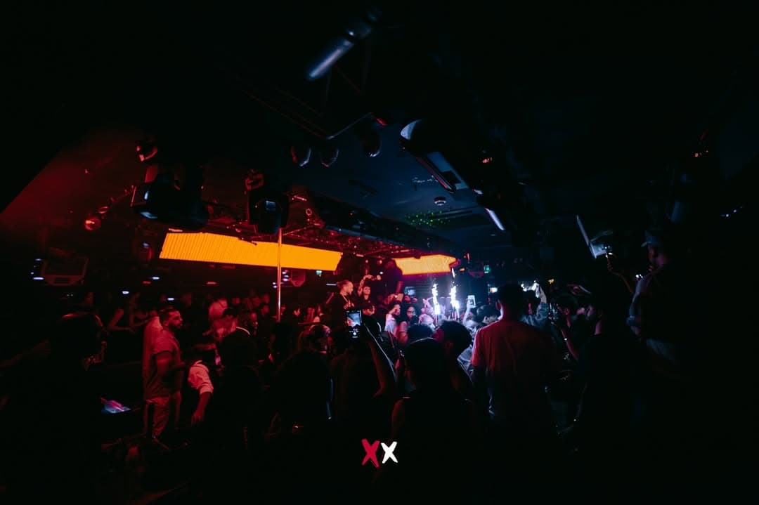 Crowd and sparklers under orange lights at Luxx London, before the club closed
