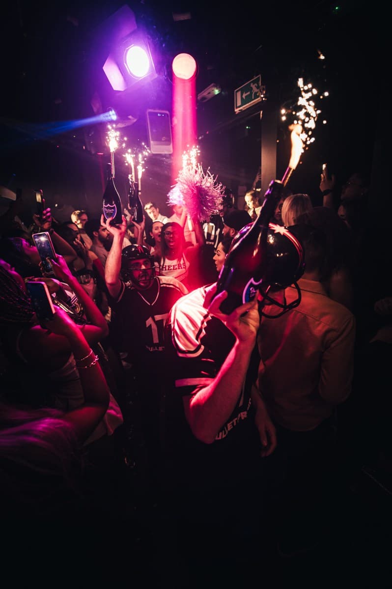 London nightclub entrance with queue and neon signage at night