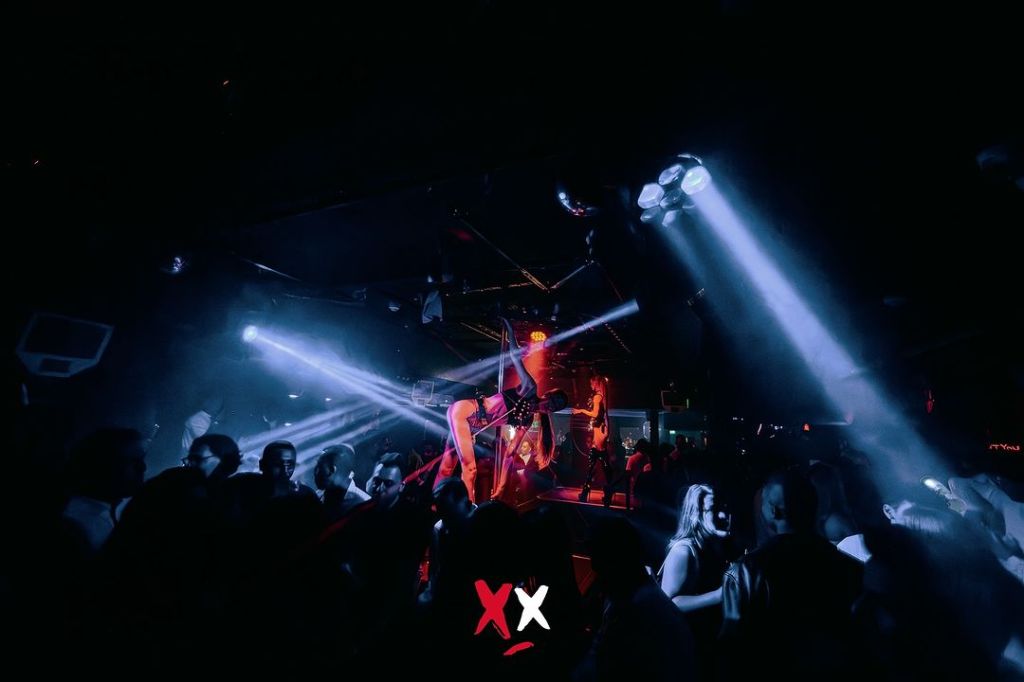 Luxx Club London tables and stage with dancers performing.
