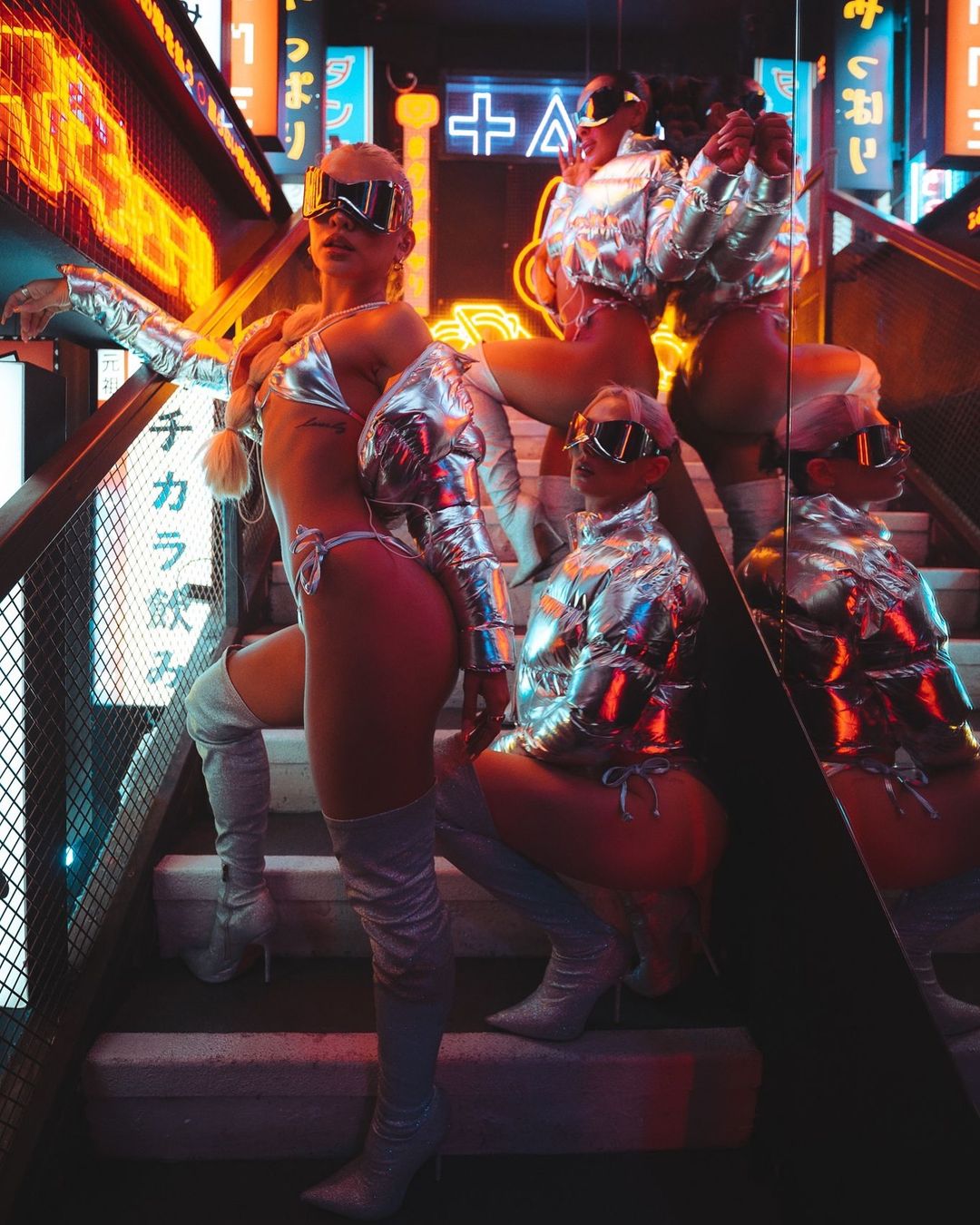 Tabu London dancers posing on the signature Tabu staircase with the Tabu London club logo behind them.