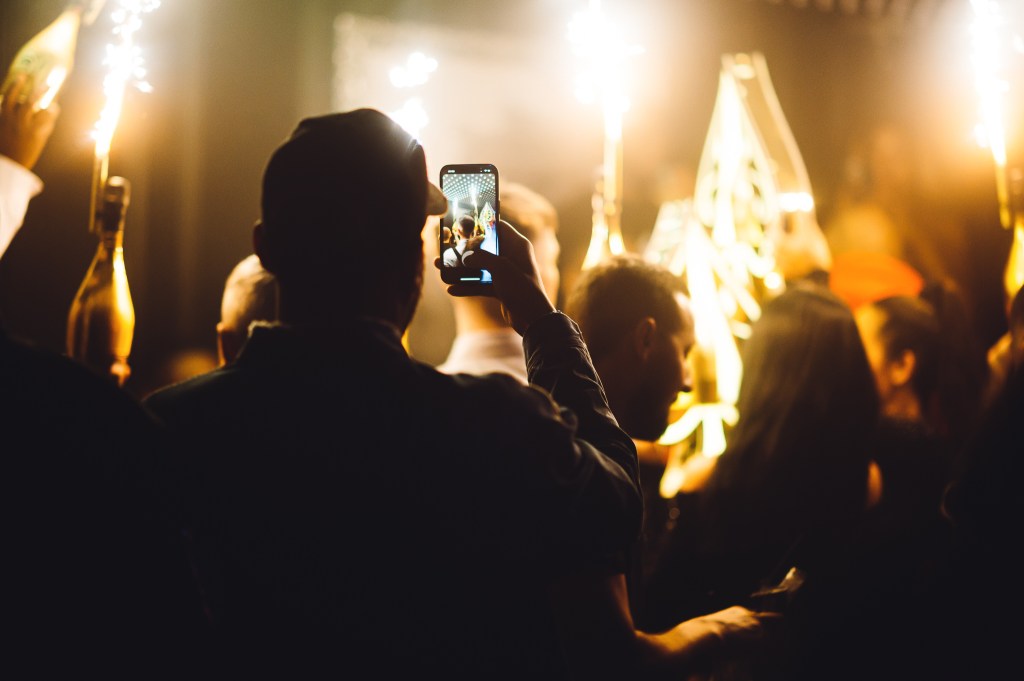 Guest taking a photo of a bottle show at Tape London, one of the best places to go clubbing in London during the week.