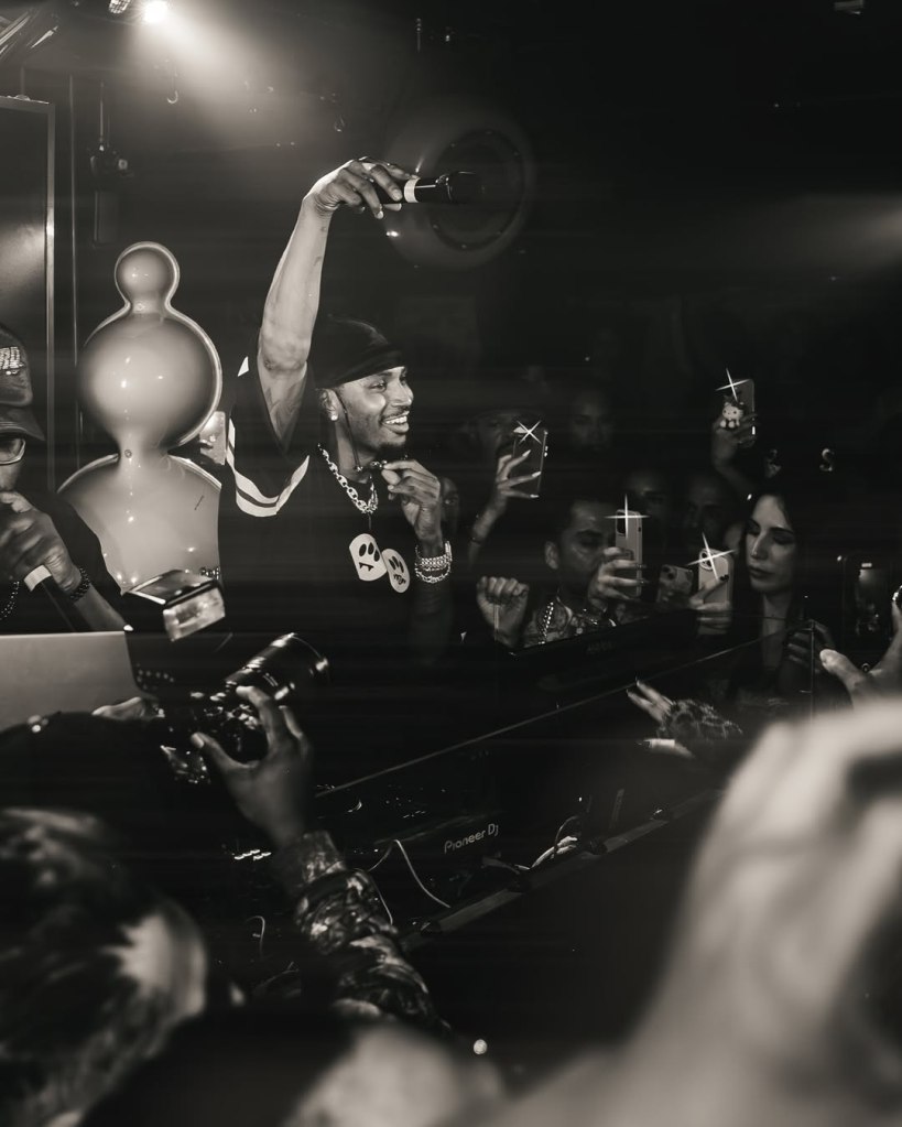 Trey Songz performing at Dear Darling while Dear Darling table clients watch and film the performance with their phones.