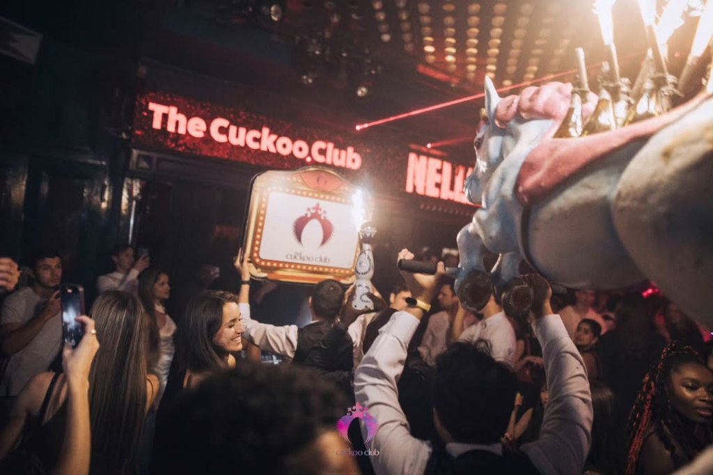Waiters at Cuckoo Club carrying bottles and bottle presenters through the crowd.