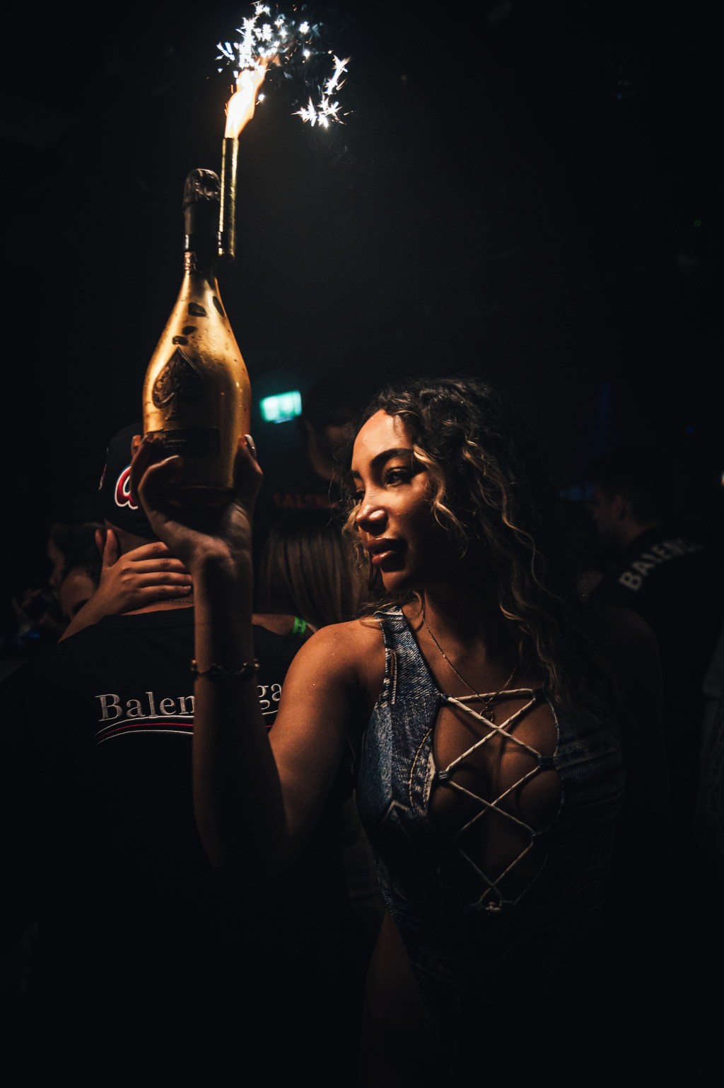 Bottle girl carrying a champagne bottle at a London club.