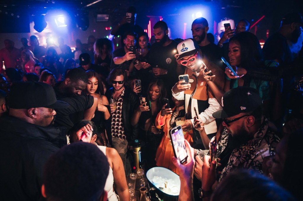 A group of guests standing at a London club VIP table.