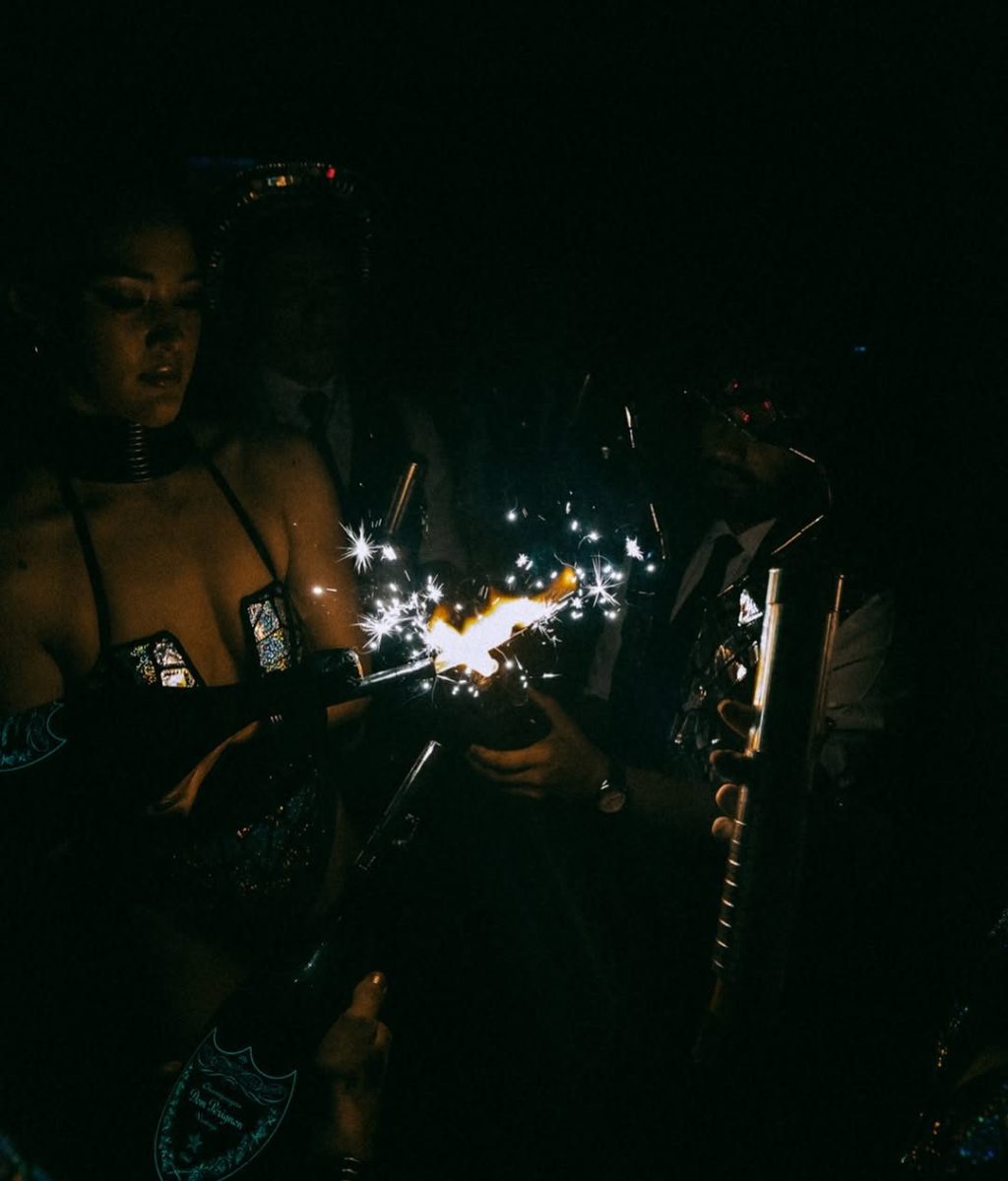 Bottle girls lighting up sparklers on top of champagne bottles inside Funky Buddha club.