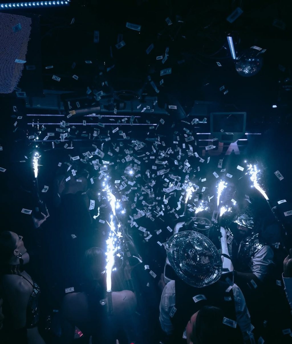 Champagne show with bottles, sparklers, and confetti inside Funky Buddha Club.